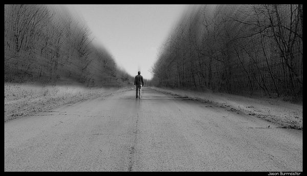 Image of man walking down an empty road.